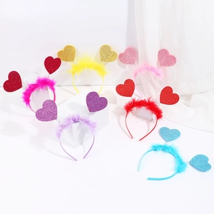 Glitter heart headbands with feather trim on geometric stands for Valentine parties