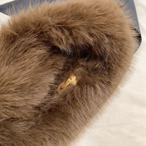 Detailed view of the luxury brown fluffy faux fur handbag with a golden metal zipper