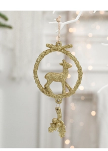 Macro view of gold glitter elk wreath ornament hanging on a Christmas tree branch