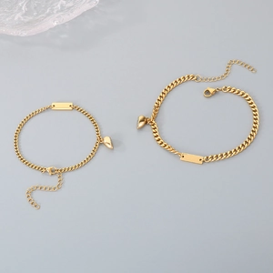 Close-up of golden stainless steel magnetic heart pendants for couple bracelets