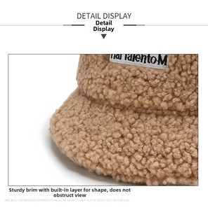 Detailed view of beige sherpa bucket hat featuring built-in brim support and logo patch