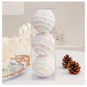 Detail of 8cm macaron Christmas balls in a clear box with textured foam surface