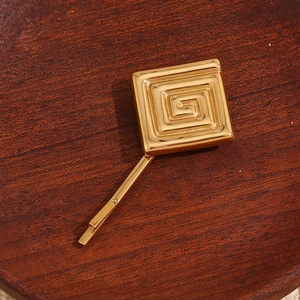 Vue détaillée d'une barrette géométrique en plaqué or 18 carats avec motif grecque