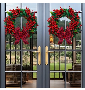 Close-up of rustic Christmas wreaths with red berries and black-red buffalo plaid bows
