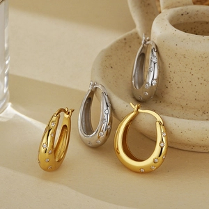 925 Sterling Silver star hoop earrings with zircon pavé on beige ceramic bowl