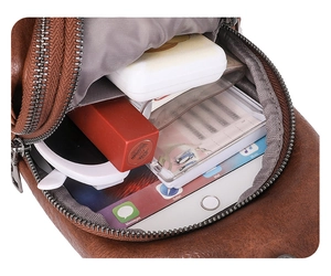 Détail intérieur du sac de poitrine en cuir marron montrant un grand espace pour iPad