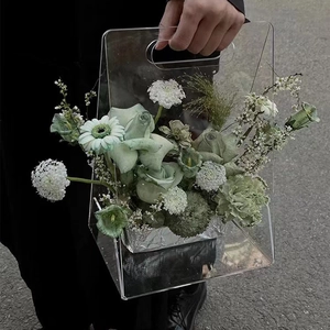 Détail d'un sac à fleurs triangulaire en acrylique transparent avec fleurs blanches