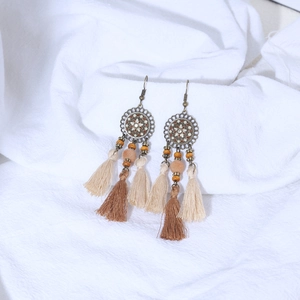 Close-up of Bohemian tassel earrings with bronze carving and layered silk thread fringes