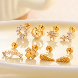 Golden F136 titanium labret studs featuring zircon flower, moon, and sun designs