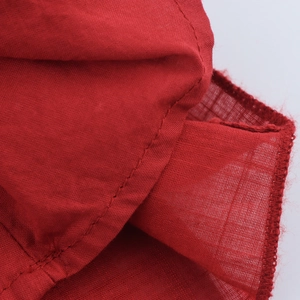 Détail macro de la texture du tissu en coton et lin rouge avec couture de bord