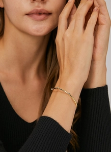 Close-up of minimalist gold plated brass cuff bracelet with zircon stones on wrist