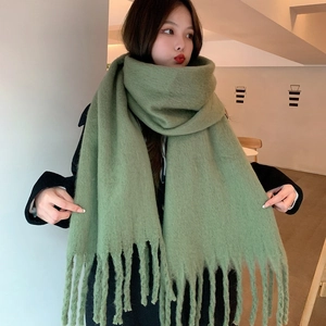 Close-up of soft green mohair scarf with tassels showing thick texture and wool-like feel
