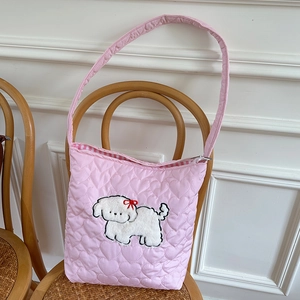 Detail of pink quilted corduroy bag with heart patterns and cute puppy embroidery