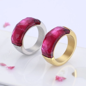 Detail view of gold and silver wide band rings with purple faceted gemstones