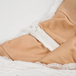 Close-up of white lace embroidery with a nude mesh lining and a hidden back zipper