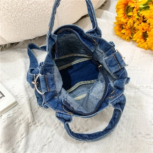 Top view of blue denim crossbody bag interior showing lining and zipper closure detail