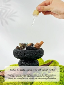 Close-up of essential oil being applied to black volcanic rock diffuser with cinnamon