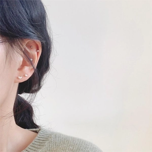 Minimalist 925 sterling silver heart and bead stud earrings set on female ear model