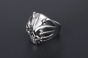 Macro shot of punk style stainless steel skull ring with detailed flame engraving