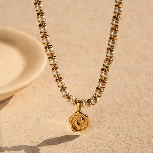 Détail du collier plaqué or 18k avec perles blanches et pendentif pièce irrégulière