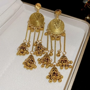 Close-up of vintage golden jhumka earrings with intricate bells and tassel chains