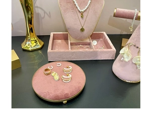 Detailed view of pink velvet jewelry display stands with elegant gold metal edges