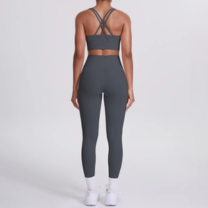 Dettaglio del reggiseno yoga con schiena incrociata e leggings a vita alta grigio scuro