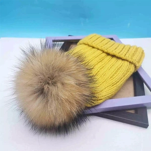 Winter chunky knit beanie with large fur pompom detail in yellow and dark brown