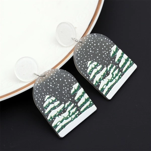 Détail macro de boucles d'oreilles de Noël en acrylique avec motif sapin sur céramique