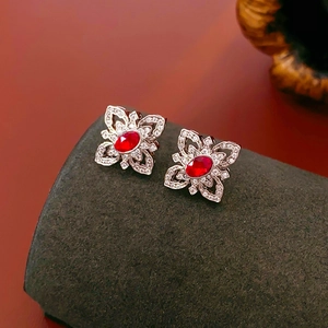 Macro shot of silver flower stud earrings with red oval zirconia and micro-pave crystals