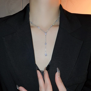 Detail of silver Y-shaped drop necklace with sparkling crystals worn by a model