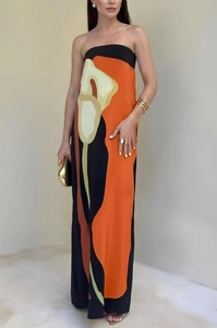 Detail view of tropical floral print on a sleek strapless maxi dress with vivid orange accents