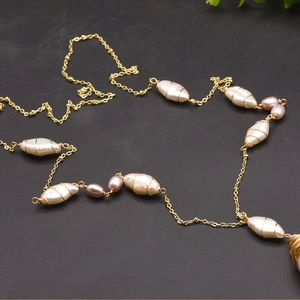 Detail view of handmade baroque pearl necklace with golden wire and purple beads