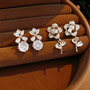 Détail de boucles d'oreilles fleurs en argent et zircons sur plateau à bijoux en velours