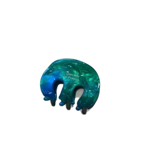 Blue-green gradient acetate hair claw clip with golden lettering on a white background