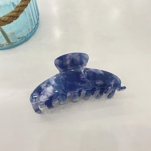 Detailed close-up of blue and white marble texture acetate hair claw clip