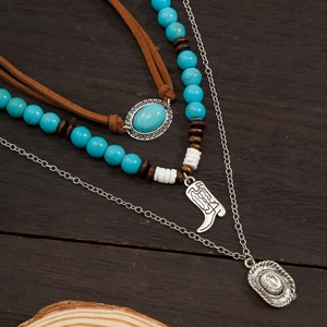 Close-up of bohemian layered necklaces with turquoise beads and cactus cowboy motifs