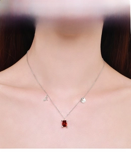 Close-up of S925 silver necklace featuring a red rectangular gemstone on female model