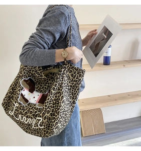 Detail of leopard print tote bag on shoulder showing large capacity and Lucky embroidery