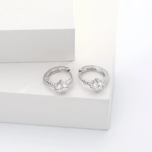 Macro detail of silver S925 earrings with spiral texture and sparkling zircon stone