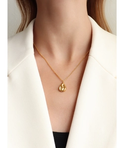 Chic gold water-drop pendant on a delicate link chain worn with a professional white blazer