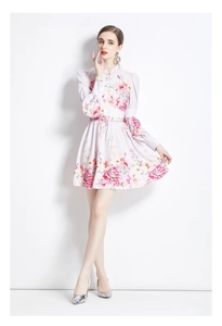 Détail d'une robe courte fleurie à manches longues avec taille ajustée et col boutonné