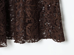 Macro de dentelle marron foncé montrant les motifs ajourés et les détails de l'ourlet
