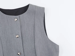 Detail of grey twill texture fabric with three silver metal buttons and round neckline