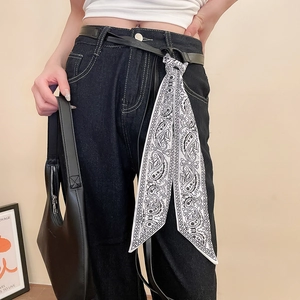 Vue détaillée d'un foulard en soie à motif paisley noir et blanc noué à la taille