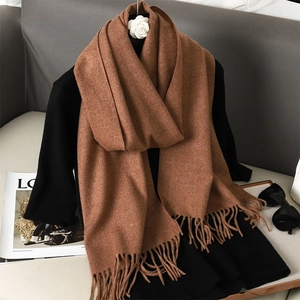 Detailed macro view of soft brown cashmere blend scarf texture with stylish fringe edges