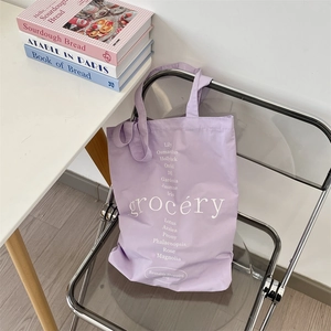 Dettaglio della borsa tote in tela viola con stampa floreale su sedia moderna