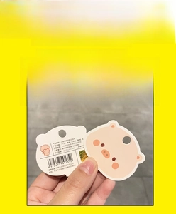 Detail of cute pig keychain packaging showing product material and authenticity card