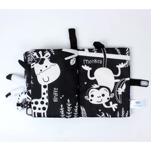 Detail of black and white soft baby book with tactile giraffe and monkey tails