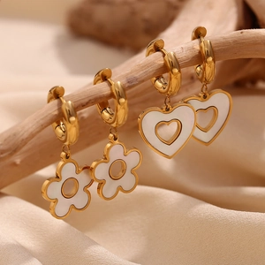 Detail of 18K gold heart and flower pendants hanging on wood branches with macro view